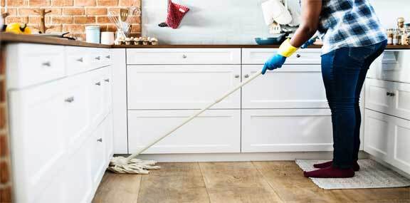 This image shows a man mopping the floor.