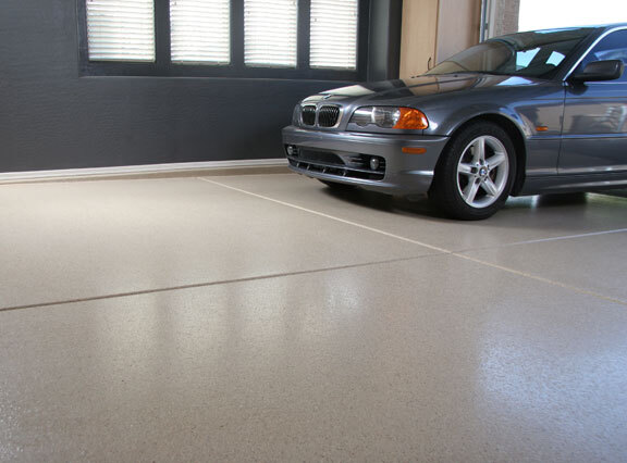 This image shows a flake epoxy floor. A gray car is parked there.