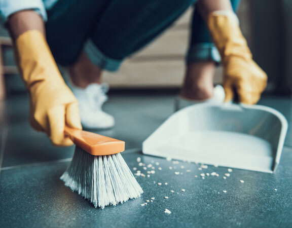 This image shows a man sweeping the floor.
