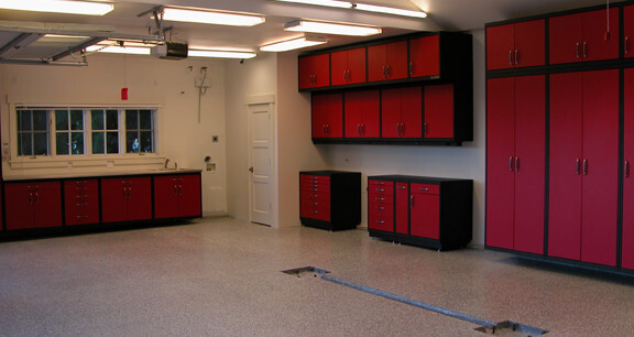 This image shows a garage floor with flake epoxy painted floor. There are cabinets on the wall.